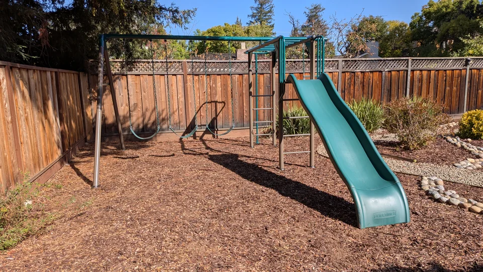Lifetime metal playset with three swings, monkey bars, and a green slide, assembled by Artem in September 2025